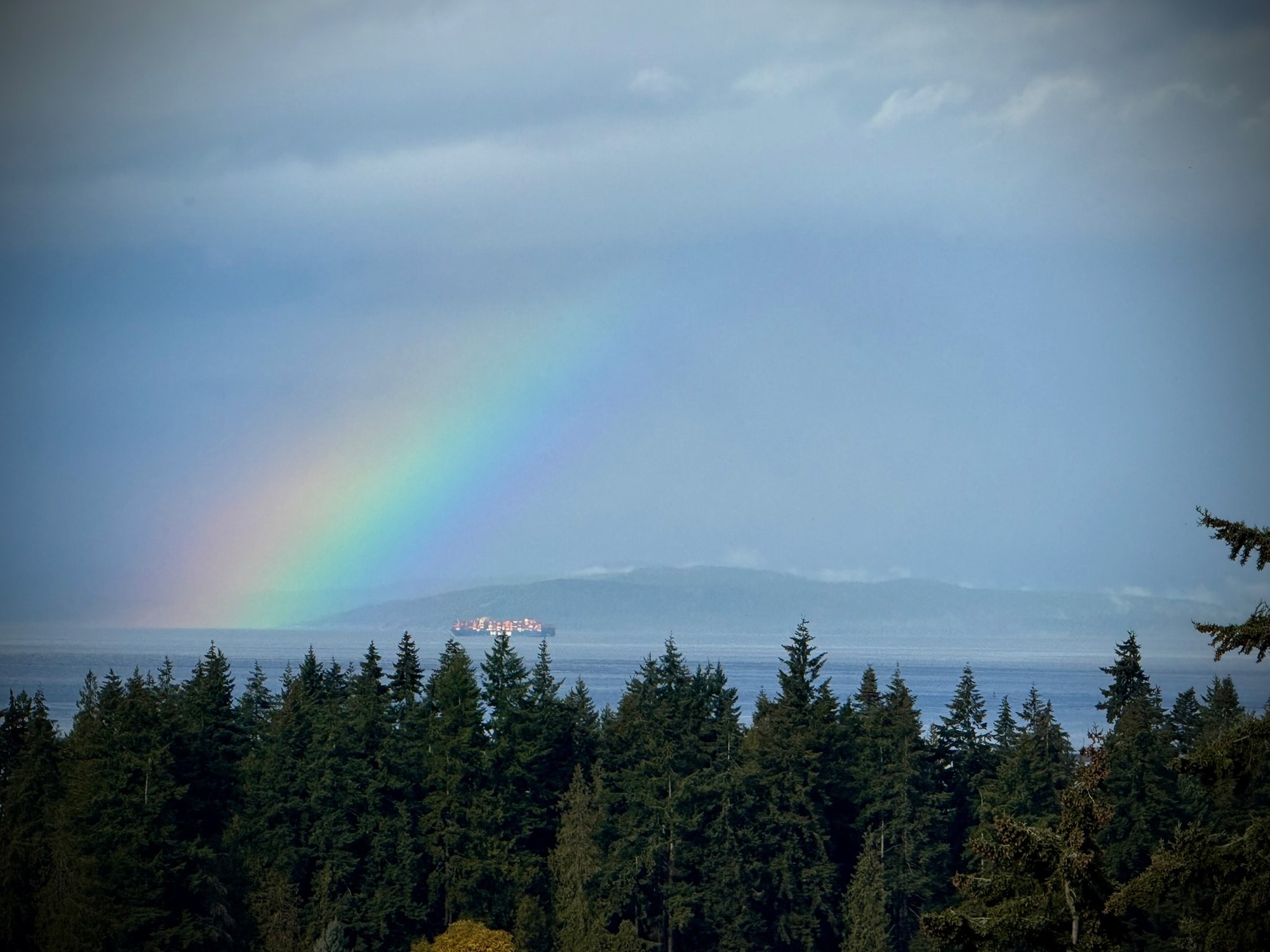 Rainbow and passing ship